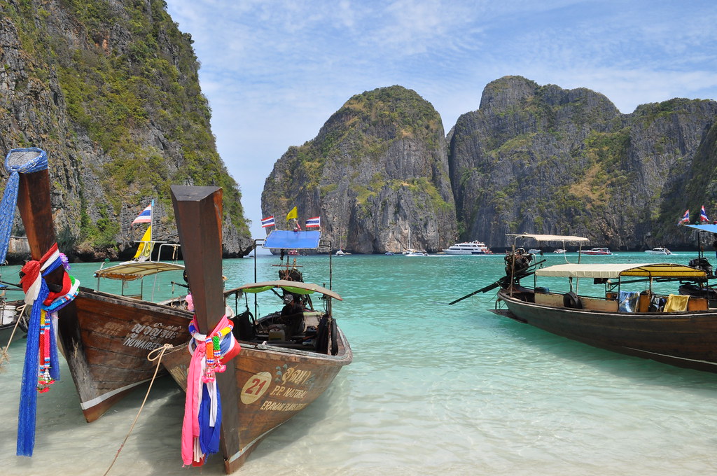 Longtail boats moored below dramatic cliffs near Phuket