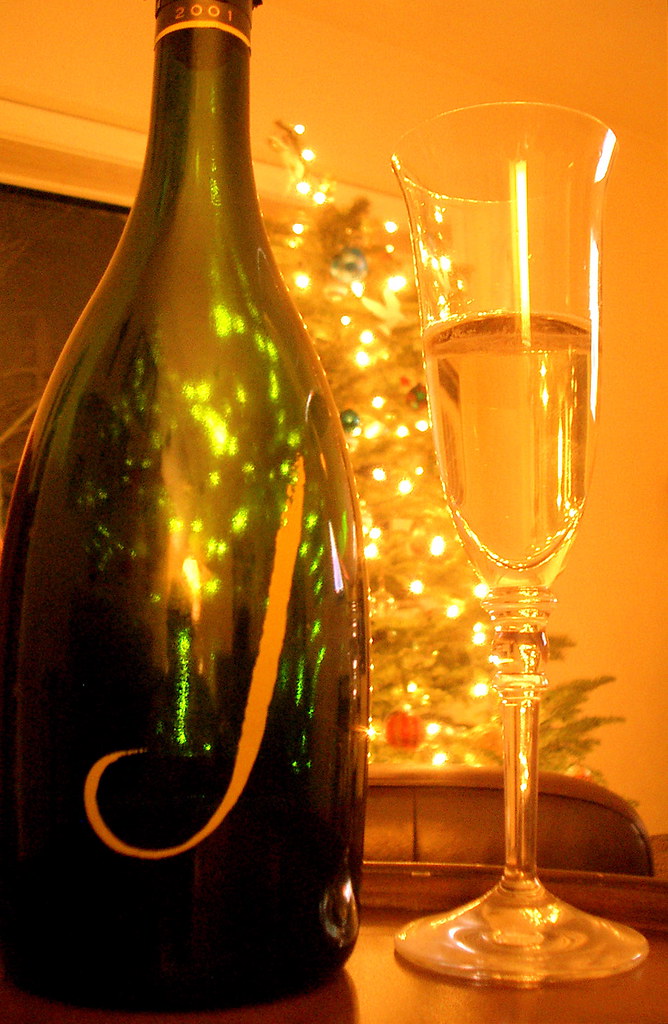 A festive glass of champagne beside warm string lights