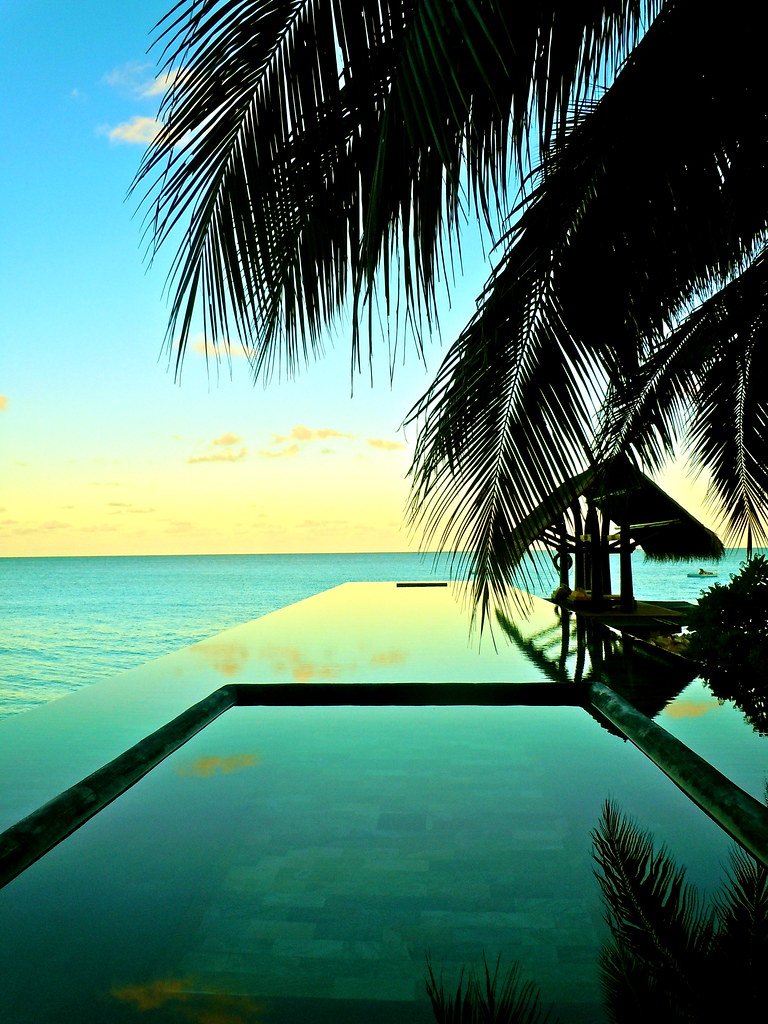 A resort infinity pool glowing at golden hour in Phuket