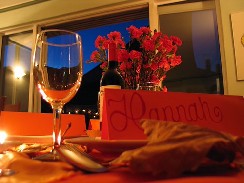 A glass of wine and roses beside an anniversary card at a Phuket dinner
